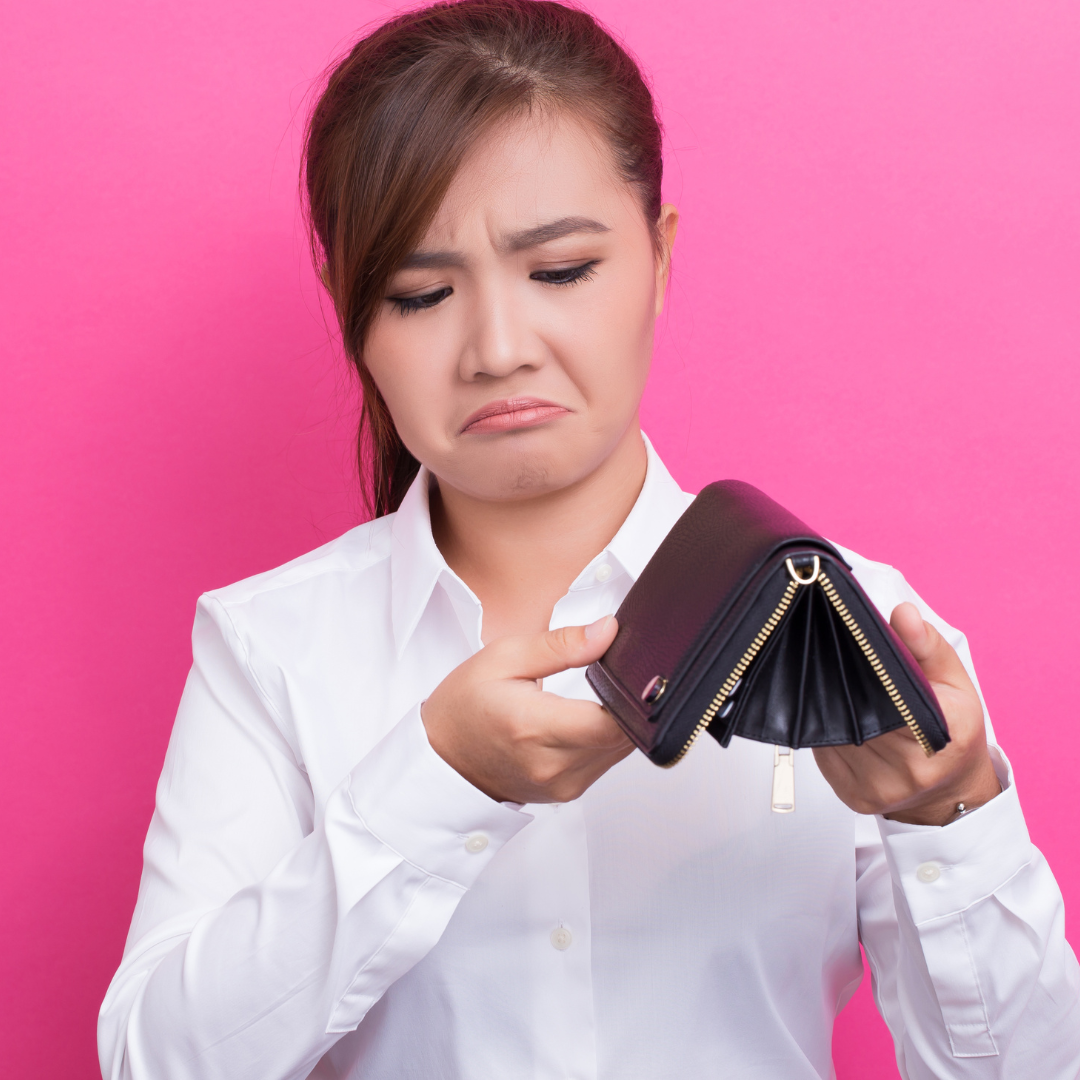 Lady showing her purse is empty holding it upside down